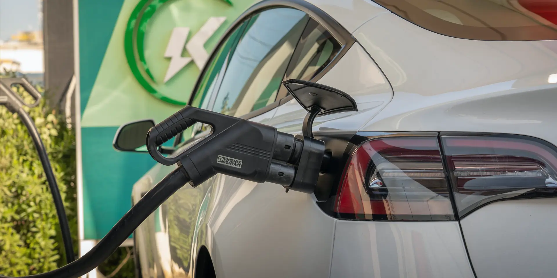 Voiture électrique blanche en charge sur une borne rapide